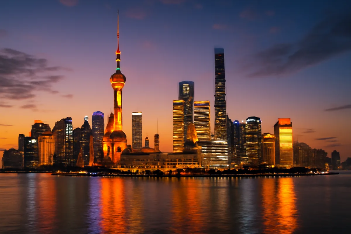 Shanghai skyline at dusk with the Oriental Pearl Tower and modern skyscrapers reflected in the Huangpu River under a dramatic twilight sky