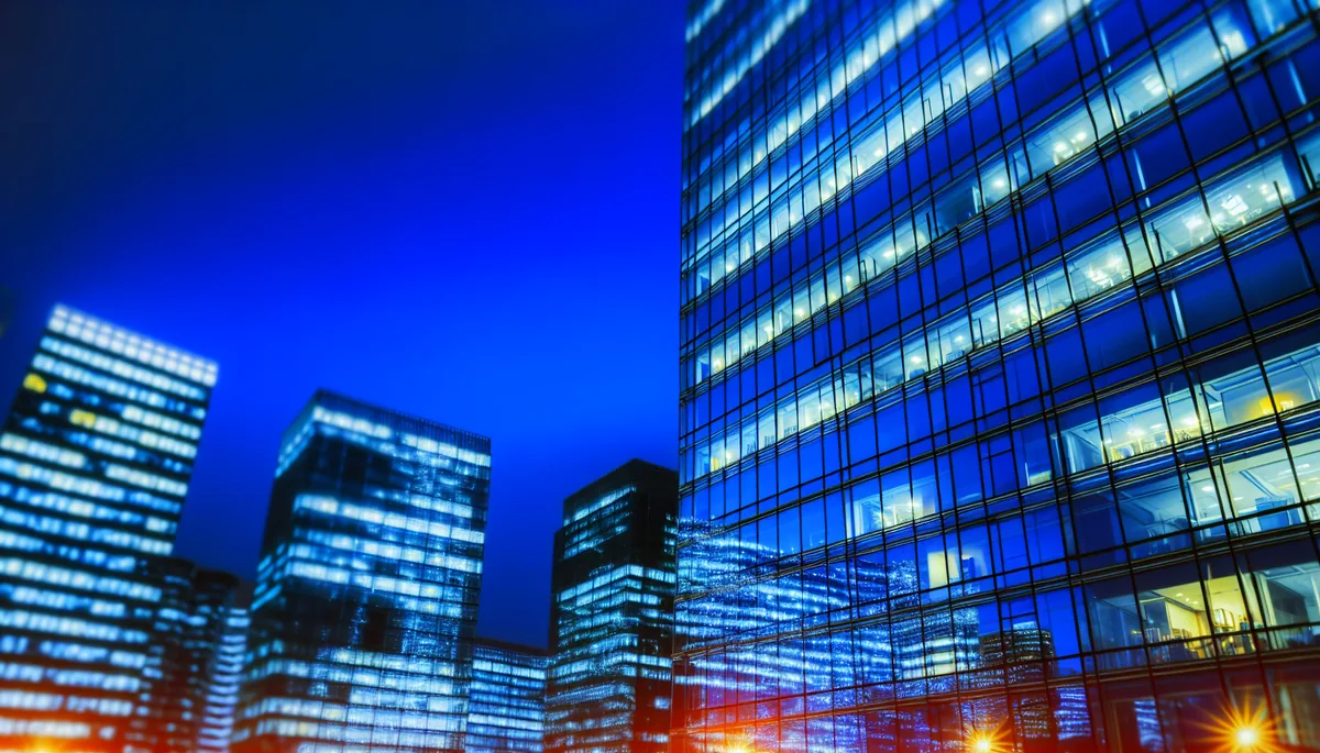 Modern city skyline at twilight with illuminated glass buildings and urban lights, representing high-speed connectivity and modern travel destinations