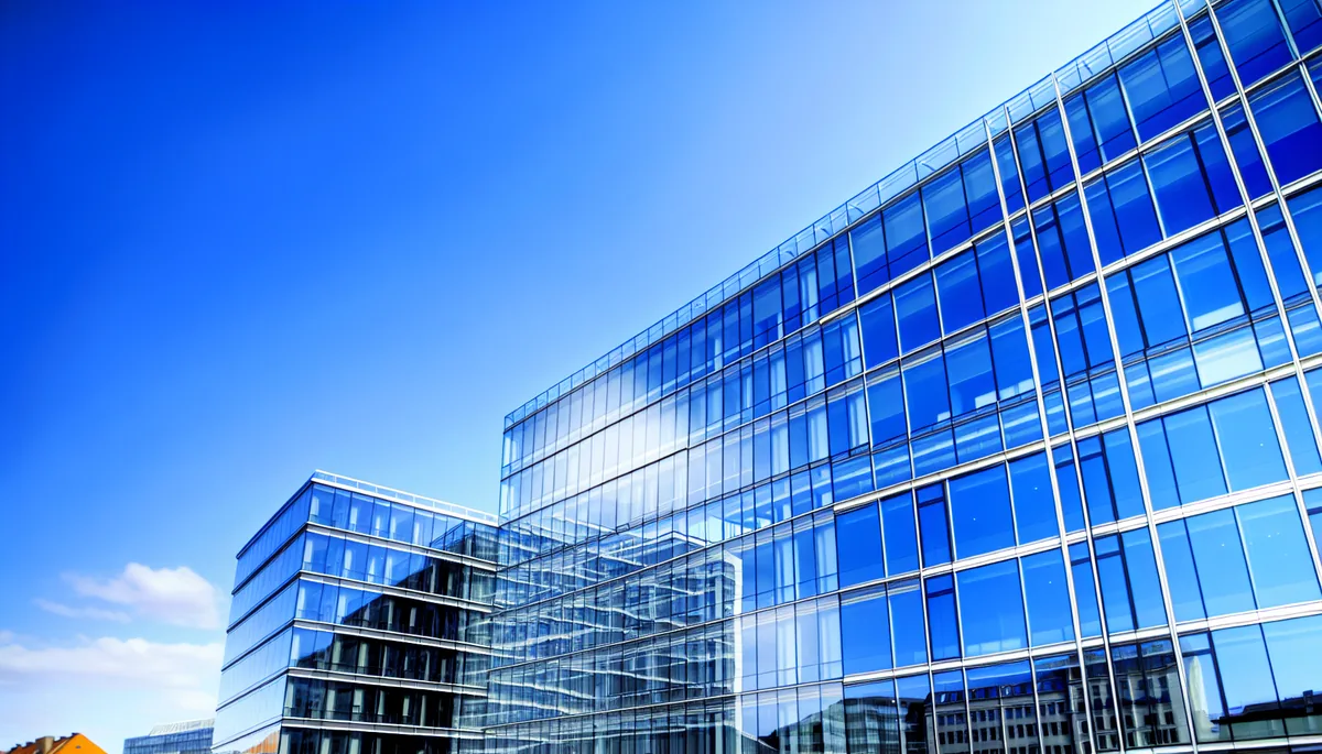 Modern glass office building in Tallinn reflecting blue sky, representing digital connectivity and technology infrastructure