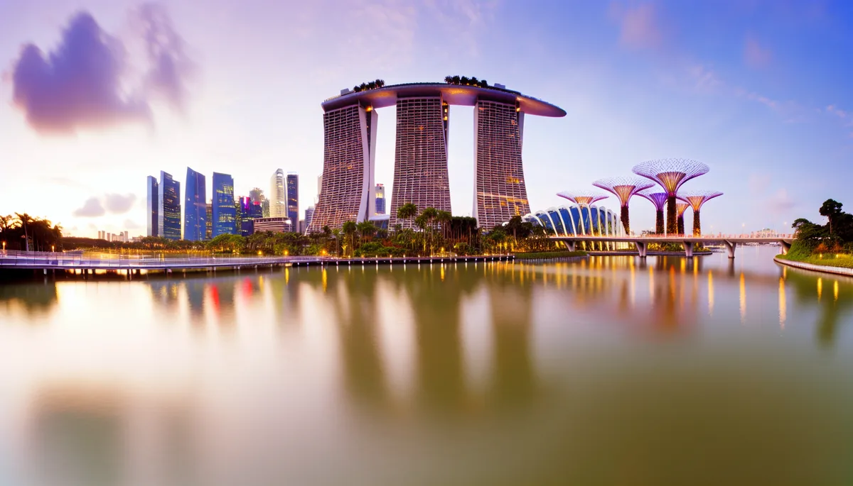 Singapore's iconic Marina Bay Sands and modern skyline reflected in calm harbor waters during golden hour