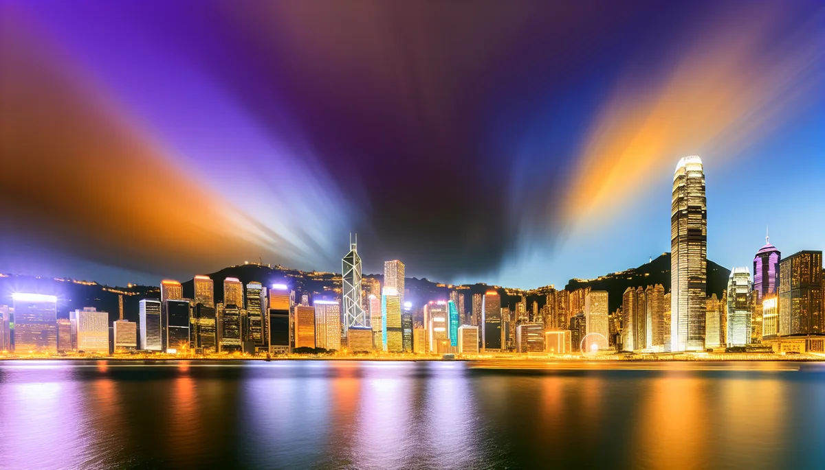 Hong Kong Victoria Harbour skyline at sunset with illuminated skyscrapers reflecting in the water